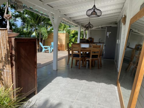 Vaste terrasse couverte à Villas aux Antilles à Saint-François avec table à manger, plantes tropicales et vue sur le jardin