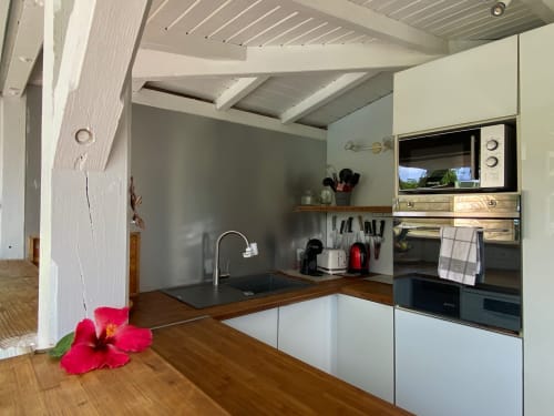 Cuisine moderne du gîte Villas aux Antilles, Saint-François, avec meubles blancs, plan de travail en bois et électroménagers intégrés