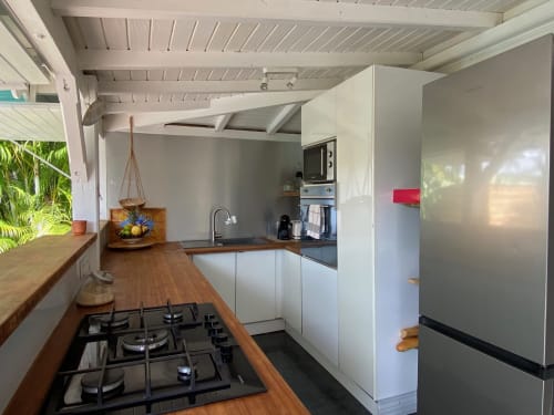 Cuisine moderne du gîte Villas aux Antilles à Saint-François : meubles blancs, cuisinière à gaz, électroménagers inox