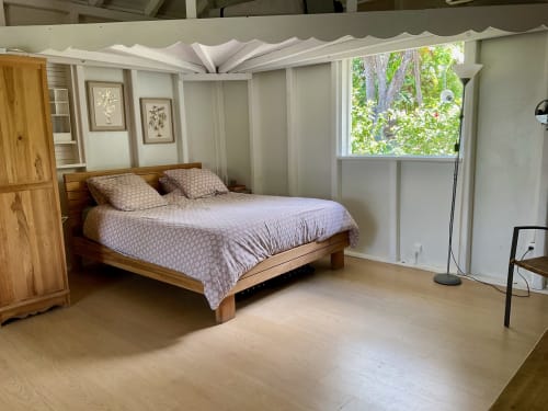 Chambre spacieuse aux Villas aux Antilles avec lit en bois, literie claire, vue sur le jardin et équipements modernes