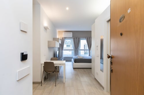 Modernes Studio-Apartment in den Magnolia Apartments Mailand mit Kochnische, Essbereich und Schlafzimmer mit Stadtblick