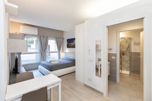 Современная студия в Magnolia Apartments Milan с кроватью, мини-кухней, рабочим столом и ванной комнатой с видом на город