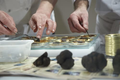 Mains du chef préparant un plat gastronomique au Domaine De Campagnac, gîte à Carsac-Aillac