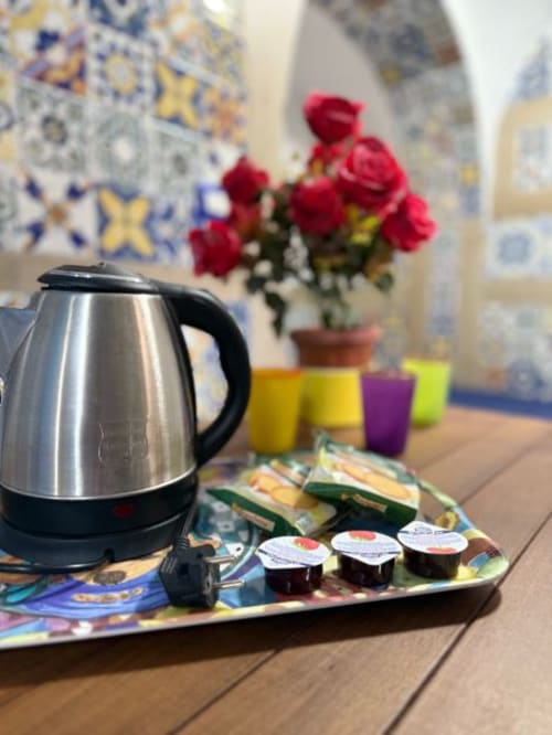 Bollitore elettrico con tè e rose fresche nella suite di San Nicola a Sorrento