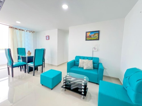 Moderna sala de estar con muebles turquesas en el apartahotel Olamar Living en Santiago de Tolú, Colombia