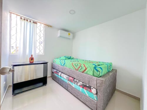 Habitación luminosa en Olamar Living con camas gemelas, aire acondicionado, escritorio de trabajo y ventanas con vistas al jardín en Santiago de Tolú