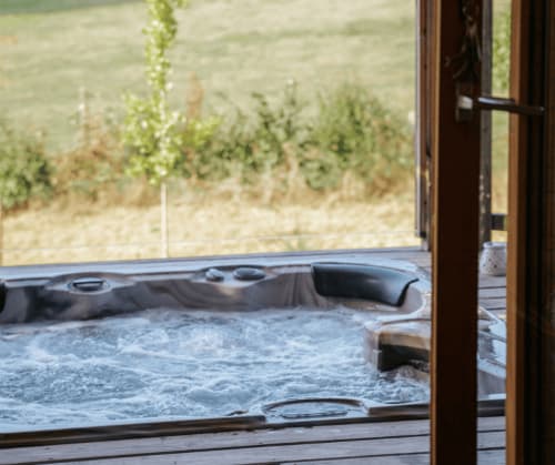 View from the lounge of the treehouse overlooking hot tub | Romantic Treehouse in France