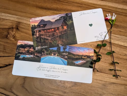 Domaine de Campagnac branding materials and gift cards on wooden surface with pink flower