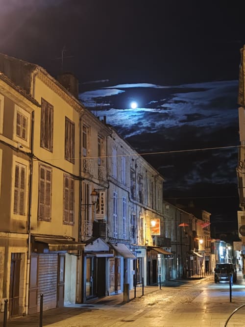 Historic cobblestone street at night with full moon, Saint-Puy France. Le Rêve d'Alice guesthouse architecture.