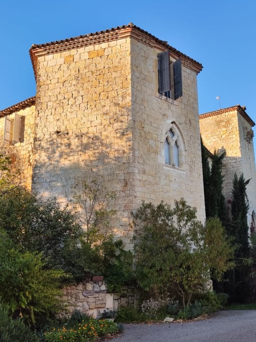 Tour en pierre du gîte Le Rêve d'Alice à Saint-Puy, avec fenêtre en arc et tuiles de terre cuite