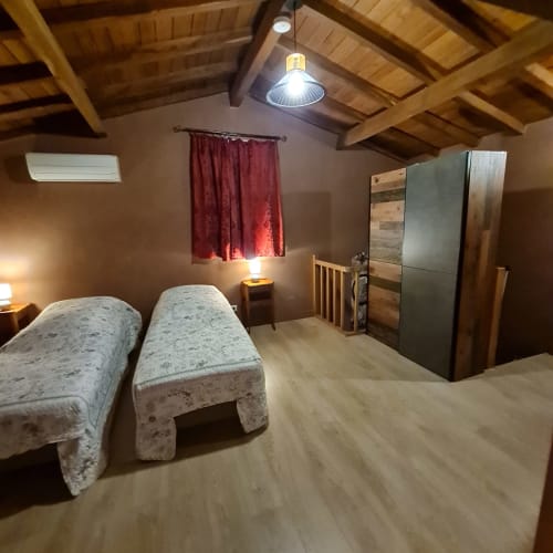 Twin bedroom of Cristal Cottage with wooden ceiling.