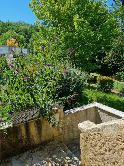 Escalier en pierre du Gîte Cristal avec vue sur le jardin verdoyant du Lot.