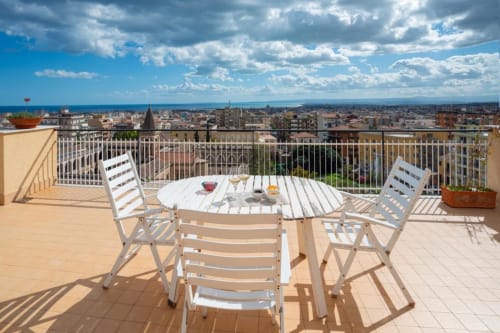 Terrazza sul tetto dell'Aparthotel Bentivoglio a Catania con tavolo da pranzo e vista sul mare
