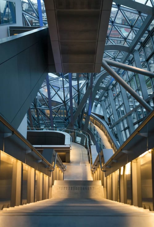 Escalier moderne aux rampes métalliques et éclairage chaleureux au Gîte des Gônes à Feyzin, montant vers le haut avec style industriel