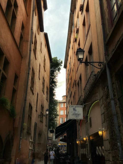 Petite rue européenne avec bâtiments en terre cuite et enseignes de café près de Feyzin, France