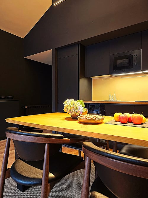 Cozinha moderna com bancada amarela e armários pretos do hotel Em Xisto em Góis, Portugal