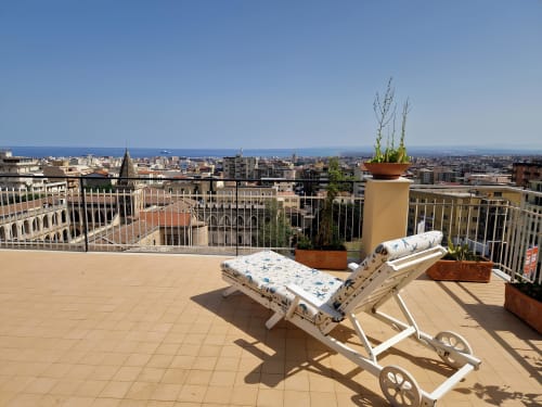 Terrazza sul tetto dell'Aparthotel Bentivoglio a Catania con sdraio con vista sullo skyline della città e sul Mar Mediterraneo