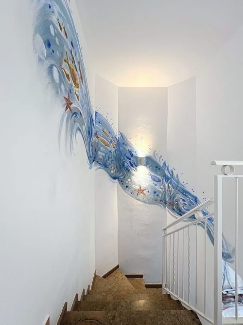 Escalera de la casa rural Mar Blau en Estartit con mural temático oceánico de olas azules y estrellas de mar