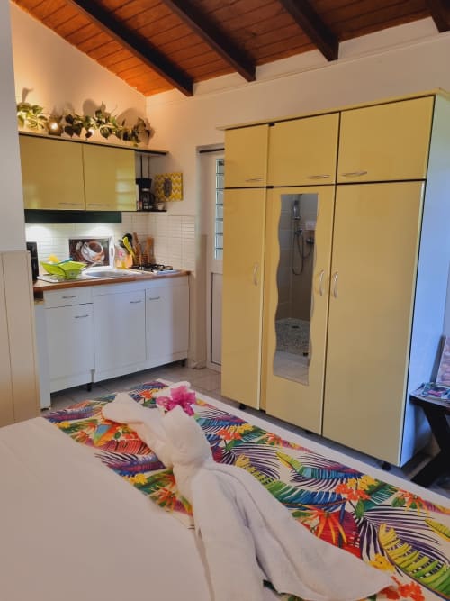 Toumblak studio at Gites Kaladja with yellow wardrobe, kitchenette, white cabinetry, and colorful floor rug in Port-Louis