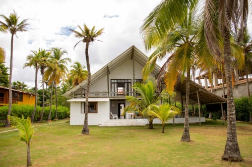 Villa blanca moderna del hotel Olamar Living en Santiago de Tolú, Sucre, rodeada de palmeras y jardín cuidado