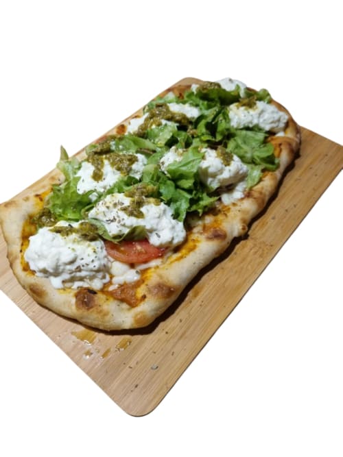 Pizza gourmet de pan plano con queso blanco, rúcula fresca y alcaparras en tabla de madera en Gites Kaladja, Port-Louis