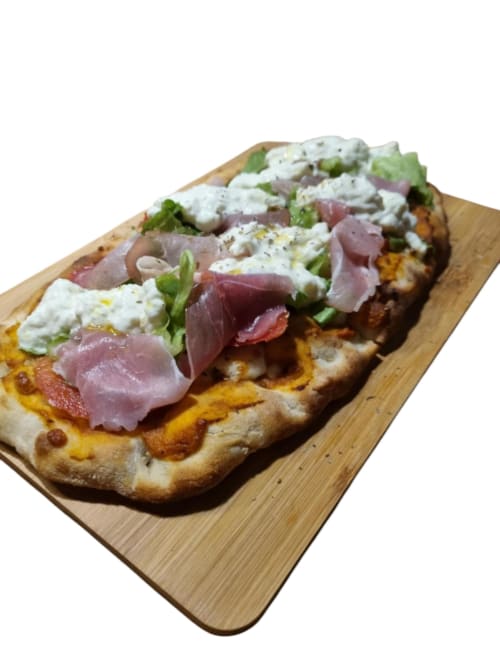 Pizza pan plano gourmet con jamón serrano, queso cremoso y verduras frescas en tabla de madera en Gites Kaladja, Guadalupe