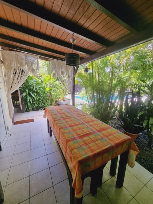 Covered patio with dining table overlooking tropical gardens at Gites Kaladja, Port-Louis Guadeloupe