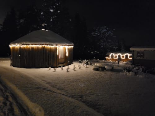 Beleuchtetes Jurte bei Les Refuges Du Chalet in Jalhay, Belgien, von Schnee umgeben mit warmem Licht in der Nacht