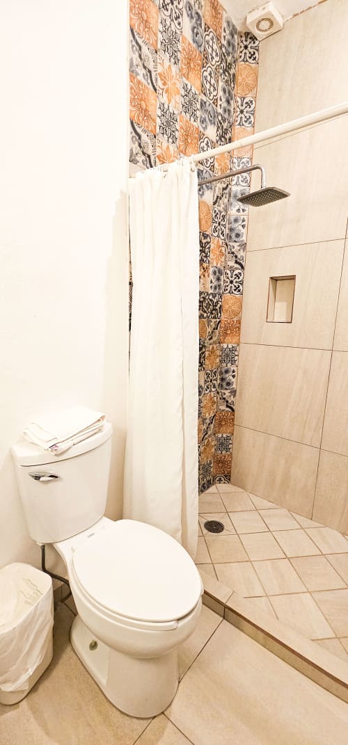Modern bathroom in La Familia Hotel Queen Room, San Blas Nayarit, featuring walk-in shower with decorative tile