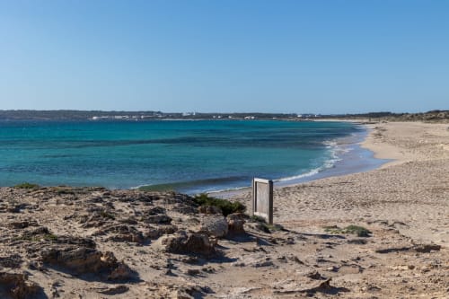 Aguas turquesas y playa de arena blanca en Formentera Especial, La Savina, España, con cielo azul despejado