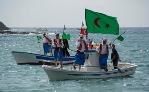Barcos de pesca con banderas verdes en la playa de Carboneras, España, cerca del Hostal Juan Carlos