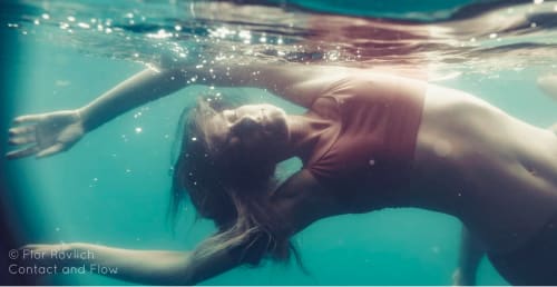 Fotografía submarina de una persona flotando en aguas turquesas del hostal Cayuco Maya en Bacalar, México