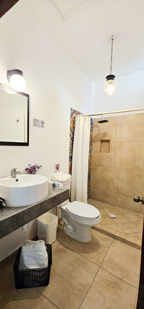 Modern bathroom in Queen Size Room at La Familia Hotel, San Blas with round sink, walk-in shower, and pendant lighting