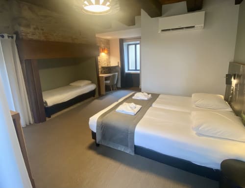 Chambre moderne de l'Hôtel Saint Roch avec lit double, lit superposé et équipements contemporains à Saint Ybard