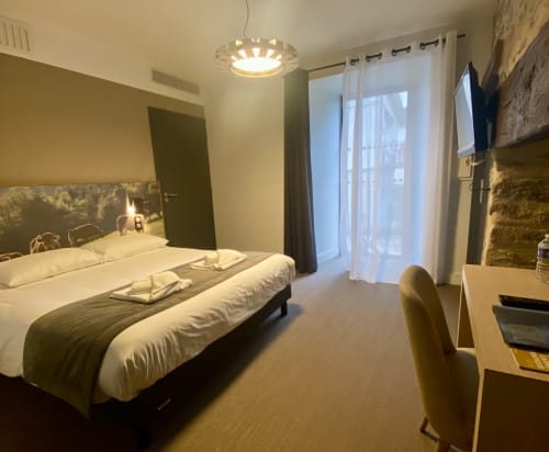 Chambre d'hôtel moderne à l'Hôtel Saint Roch à Saint-Yrieix avec lit double, accès au balcon et décoration contemporaine