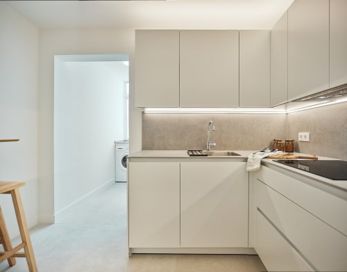 Cocina moderna en apartamento de Puerto Santa María con gabinetes color beige, electrodomésticos de acero inoxidable y distribución abierta