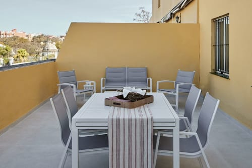 Terraza soleada en Wehost Costaluz con mesa de comedor, zona de descanso y vistas a la ciudad en Puerto Santa María