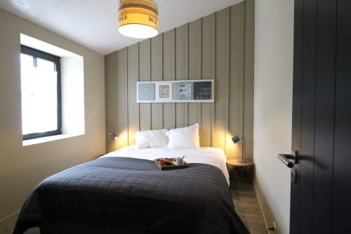 Chambre moderne du gîte Moulin d'Angibaud à La Flotte avec lit queen-size, mur d'accent et éclairage chaleureux