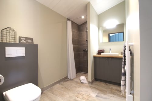 Salle de bain moderne du gîte Vert au Moulin d'Angibaud, La Flotte, avec vanité noire, douche à l'italienne et décor contemporain