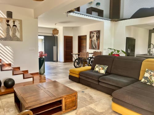 Séjour moderne à la villa Les Hébergements Passion en Martinique : canapé gris, mobilier en bois, et aménagement ouvert