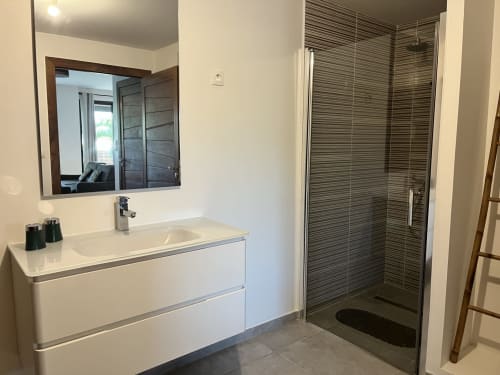 Salle de bain moderne de la villa Passion Cannelle aux Hébergements Passion, Les Trois-Ilets avec vanité blanche, miroir et douche ouverte