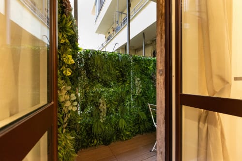 Balkon der Magnolia Apartments Mailand mit üppiger grüner Pflanzenwand und Grünpflanzen, Blick auf Innenhof