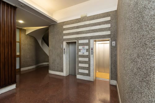 Modernes Foyer des Magnolia Apartments Mailand mit Aufzügen, strukturierten Wänden und zeitgenössischem Design