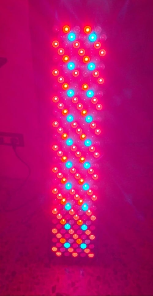 Glowing neon DNA helix in vibrant pink and cyan colors against magenta background at CasaRosada boutique hotel, Vidracco
