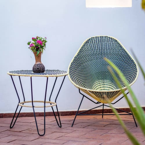 Mobiliario de patio estilo mediados de siglo con flores rosas en la boutique hotel Casa Sofi Oaxaca