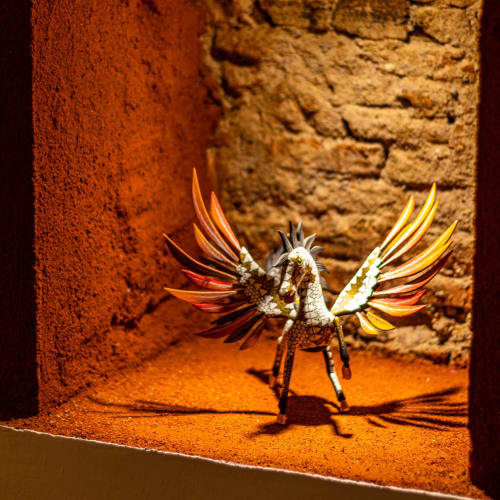 Escultura de pájaro colorido en patio rústico de la posada Casa Sofi Oaxaca, Oaxaca de Juárez México