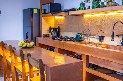 Cocina moderna en Casa Sofi Oaxaca con mesa de comedor de madera, estufa a gas e iluminación cálida en Oaxaca de Juárez