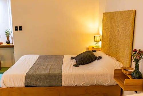Dormitorio acogedor en Casa Sofi Oaxaca con sábanas blancas, cabecera dorada e iluminación cálida en Oaxaca de Juárez