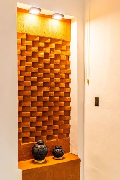 Nicho decorativo en Casa Sofi Oaxaca con bloques de terracota texturizados, vasijas de cerámica e iluminación cálida