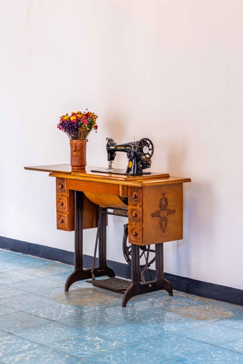 Máquina de coser Singer vintage con flores coloridas sobre escritorio de madera en Casa Sofi Oaxaca
